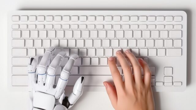 Robot and human hands typing.